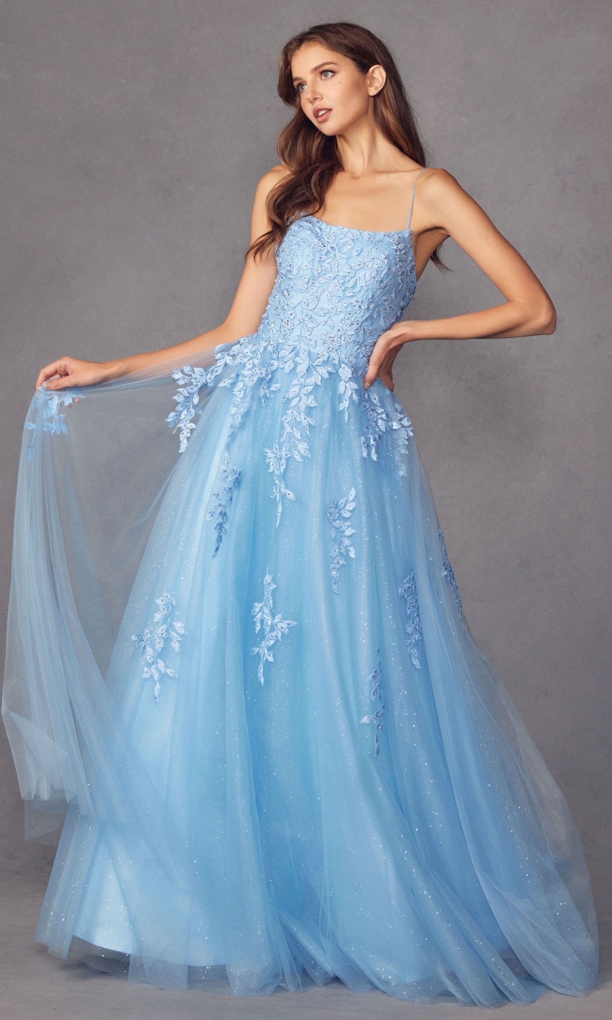A woman poses gracefully against a gray background wearing the Corset-Back Long Glitter-Tulle Prom Ball Gown 260.